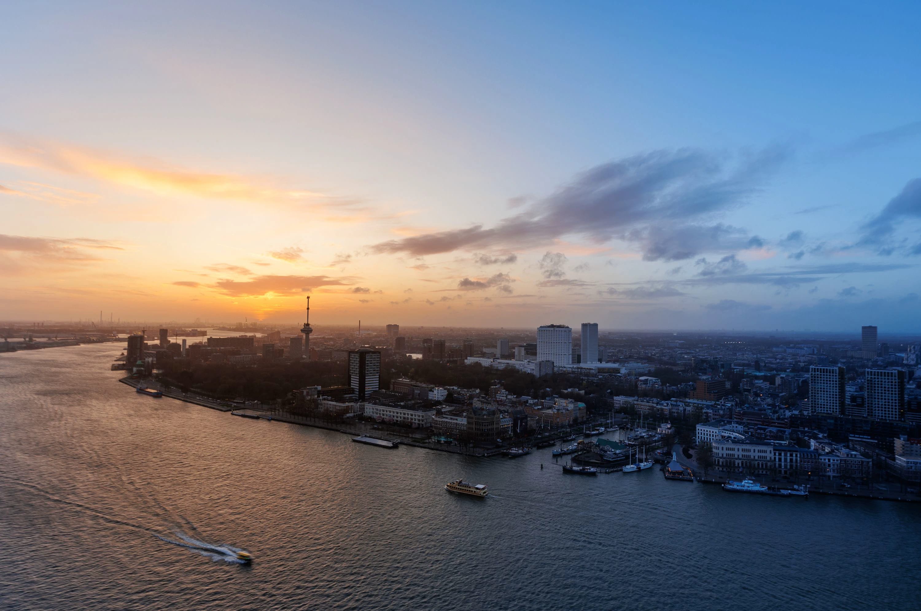 Luchtfoto van Rotterdam en de Maas in het blauwe uur.