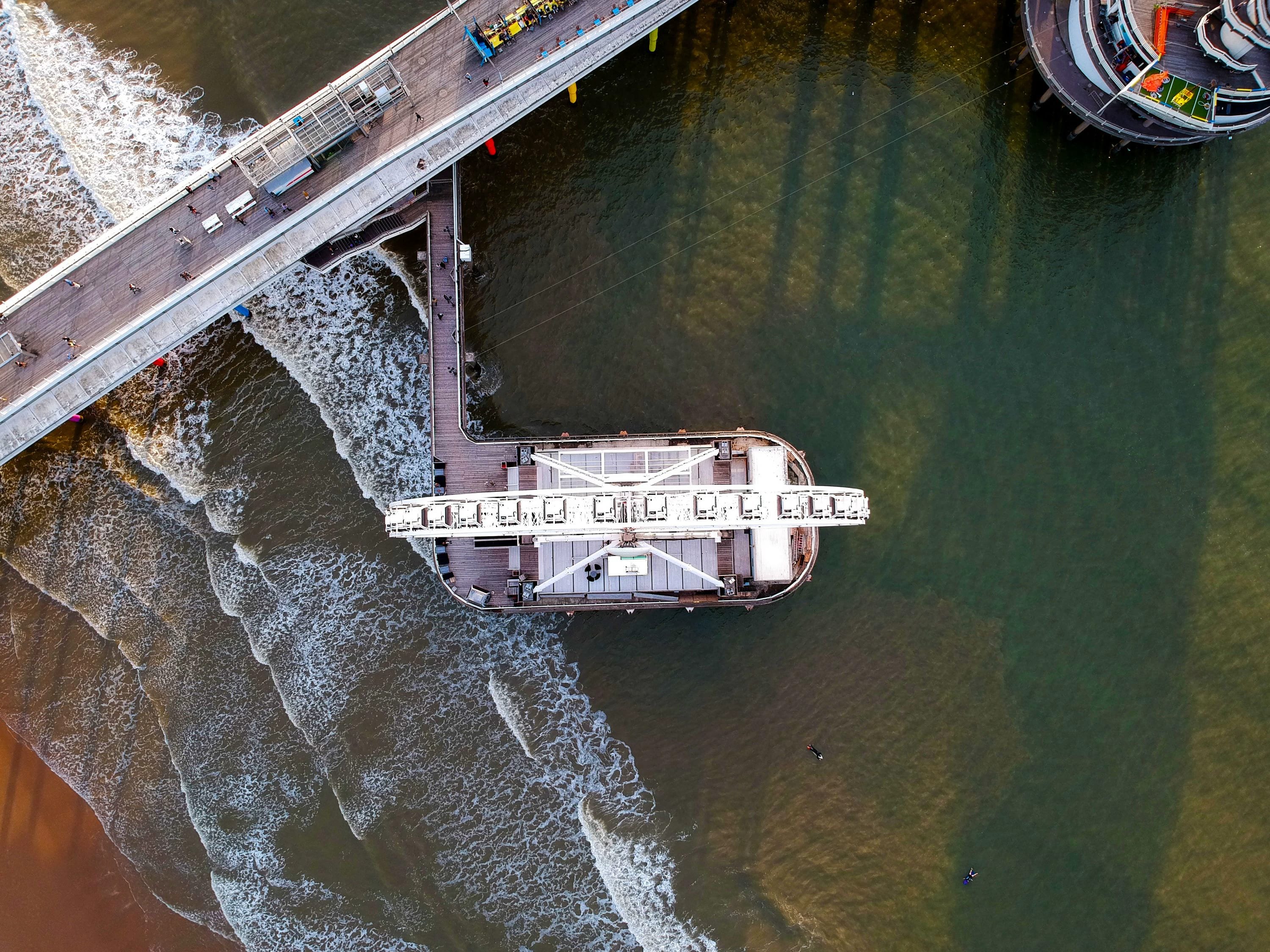 Top-down luchtfoto van de Pier van Scheveningen, met strand, zee en attracties.