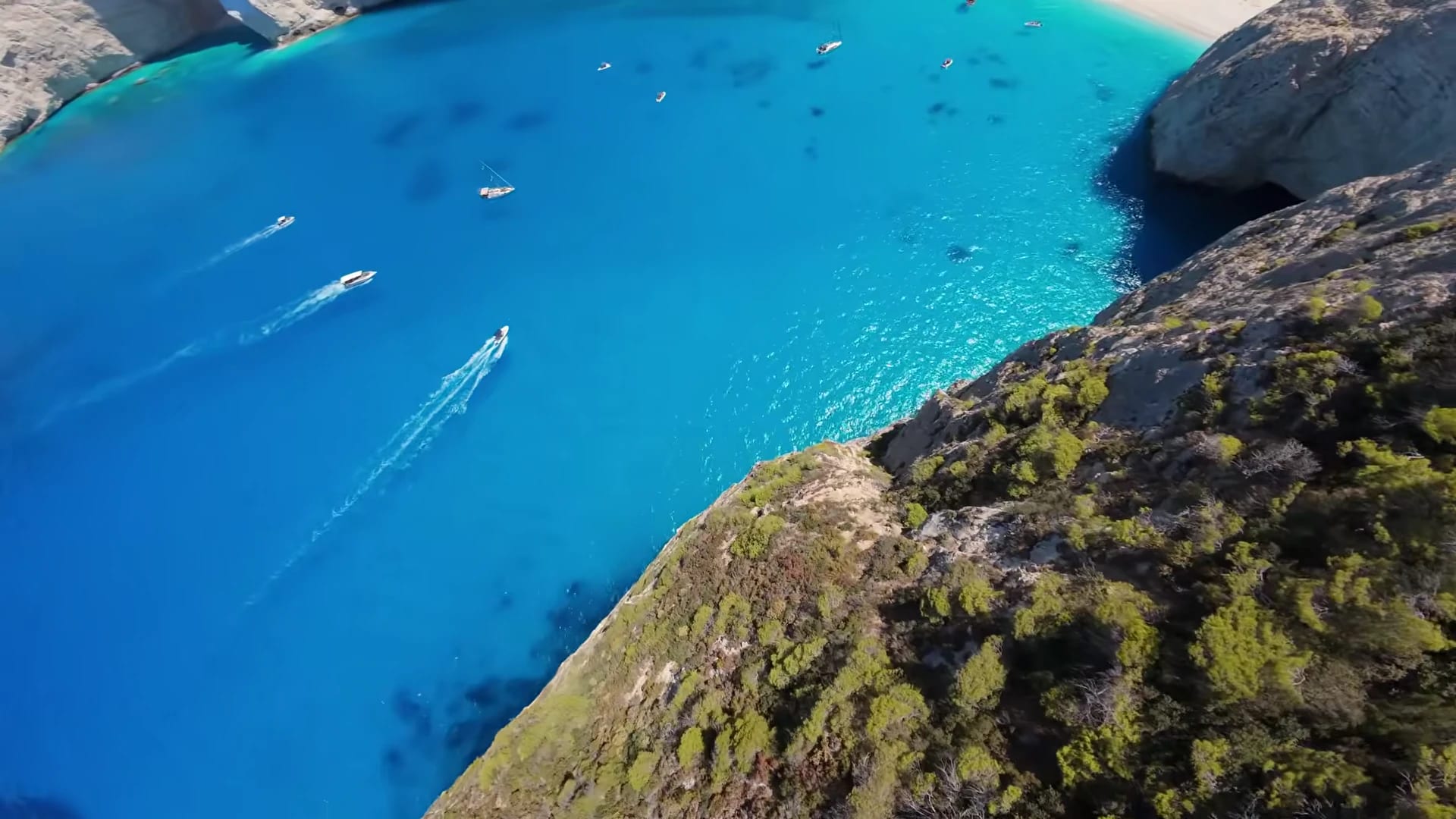 Luchtbeeld van een turquoise baai en kliffen in Griekenland.